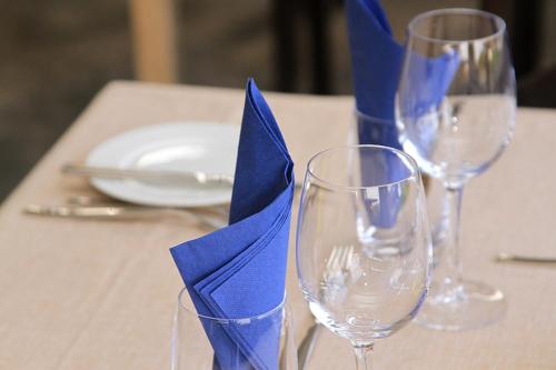 a table with two wine glasses with blue napkin at Arusha Villa Karamu Coffee Estate in Usa River