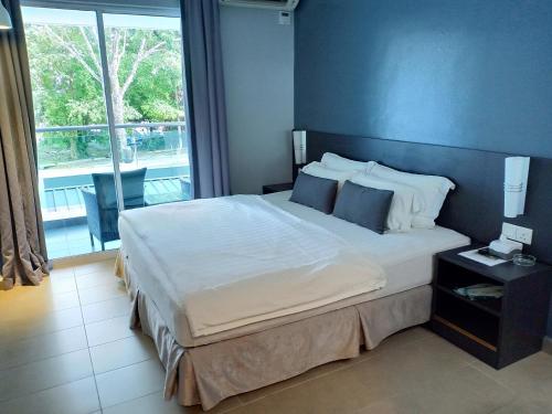 um quarto com uma cama grande e uma janela grande em G Langkawi Motel em Kuah