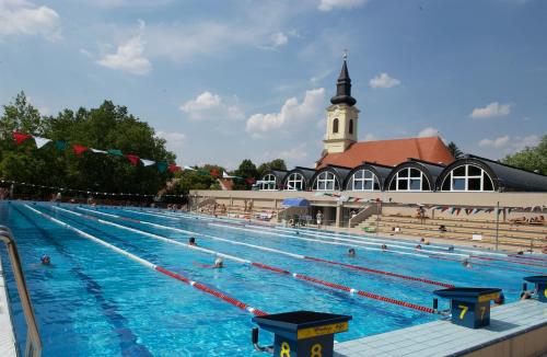 a large swimming pool in front of a building at Hunguest Hotel Gyula in Gyula