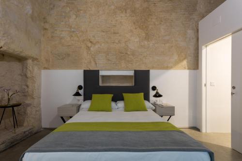 a bedroom with a large bed with green pillows at La Puerta de Palacio - Adults Only in Seville