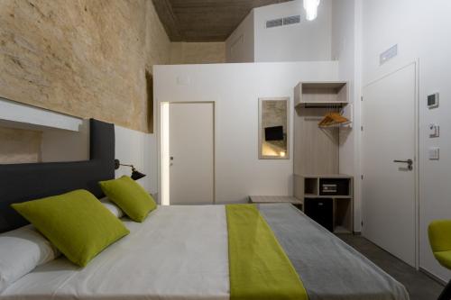 a bedroom with a large bed with green pillows at La Puerta de Palacio - Adults Only in Seville