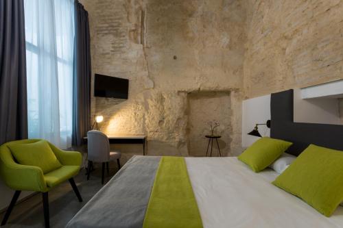 a bedroom with a large bed with a yellow and green at La Puerta de Palacio - Adults Only in Seville