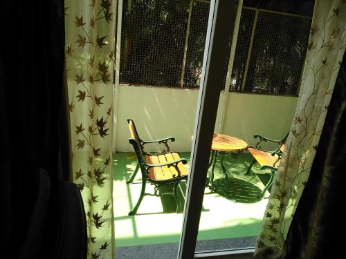 a table and a chair in a room with a window at Mrugavani Resort & Spa in Hyderabad