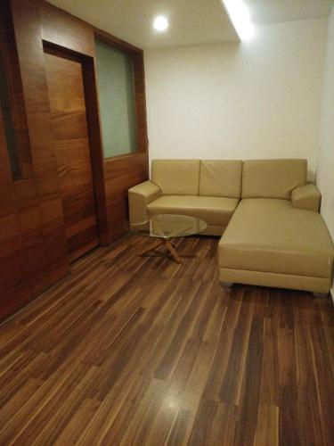 a living room with a couch and wooden floors at Mrugavani Resort & Spa in Hyderabad