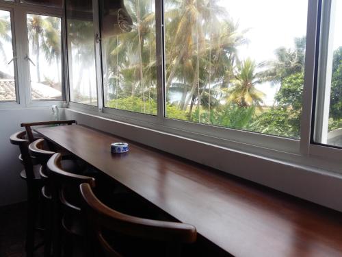 a table with chairs in front of a window at Southern Comforts - Galle Fort in Galle