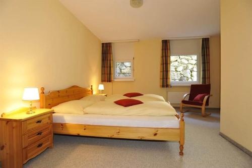 a bedroom with a large bed and a chair at Chalchboda in Arosa