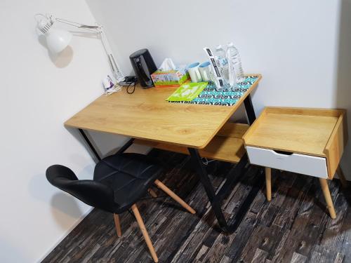 a wooden desk with a chair and a lamp on it at SHAHALAM ALLBESS@TREFOIL in Setia Alam
