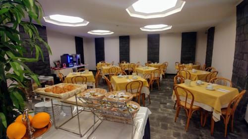 a dining room with tables and chairs with yellow tables and tablesktop at Hotel Vittoria in Genova