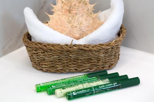 a basket with two green toothbrushes next to a toothbrush at White Pearls-Adults Only Luxury Suites in Kos Town