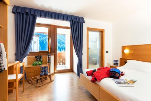 a bedroom with a bed with a helmet on it at Albergo alla Posta in Madonna di Campiglio