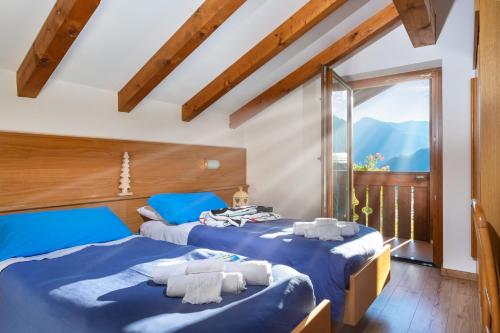 two beds in a room with a window at Albergo alla Posta in Madonna di Campiglio