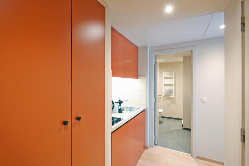 a kitchen with orange cabinets and a sink at Appart'City Confort Bruxelles Centre Gare du Midi in Brussels