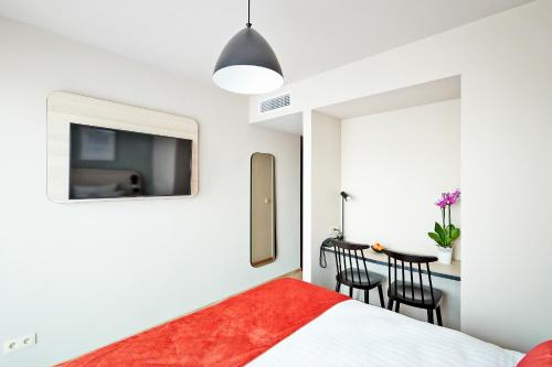 a bedroom with a bed and a table with chairs at Appart'City Confort Bruxelles Centre Gare du Midi in Brussels