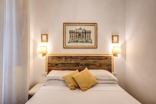 sypialnia z łóżkiem z 2 żółtymi poduszkami w obiekcie Ripetta 226 w Rzymie
