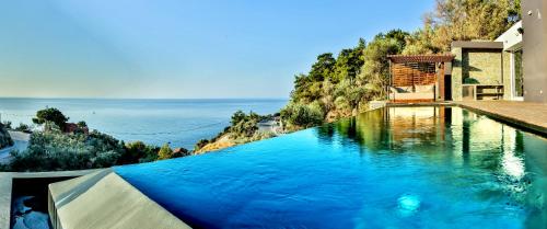 a swimming pool with a view of the ocean at Infinity Villa in Plomarion