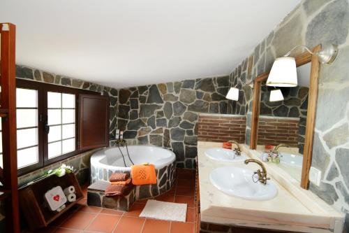 a bathroom with two sinks and a bath tub at Moinho da Capela in Campo Maior