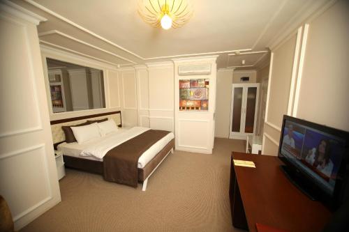 a bedroom with a bed and a flat screen tv at North Point Hotel in Samsun