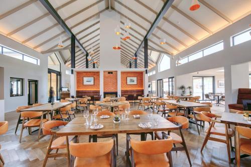 a dining room with tables and chairs and windows at Knysna Hollow Country Estate in Knysna