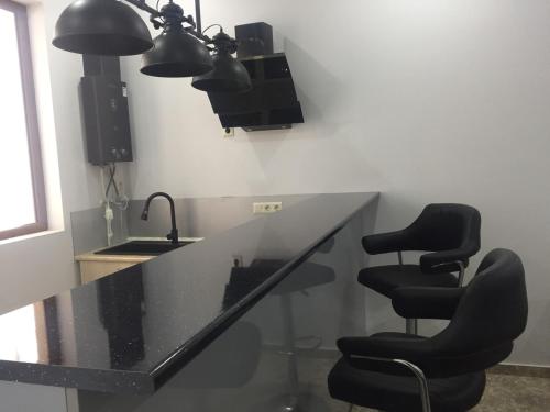 a kitchen with a counter with two chairs and a sink at The K Tbilisi in Tbilisi City