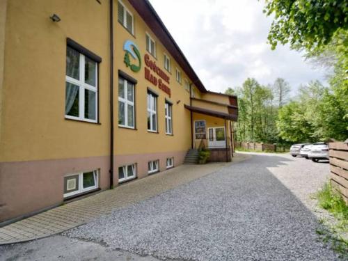 ein gelbes Gebäude mit einem Schild an der Seite in der Unterkunft GOŚCINIEC NAD SAWĄ in Handzlówka
