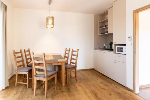 a kitchen with a table and chairs in a room at Apartmány Tlustý svišť in Vaclavov u Bruntalu