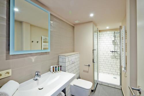 a bathroom with a sink and a toilet and a mirror at Appart'City Confort Bruxelles Centre Gare du Midi in Brussels