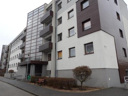 ein hohes weißes Gebäude mit einem Baum davor in der Unterkunft Szybowników 1 in Piła