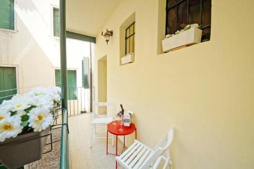 - un balcon avec une table, des chaises et des fleurs dans l'établissement San Marco Apartment Fabbri, à Venise
