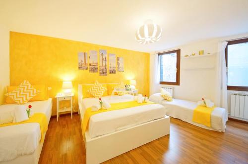 - 2 lits dans une chambre de couleur jaune et blanche dans l'établissement San Marco Apartment Fabbri, à Venise