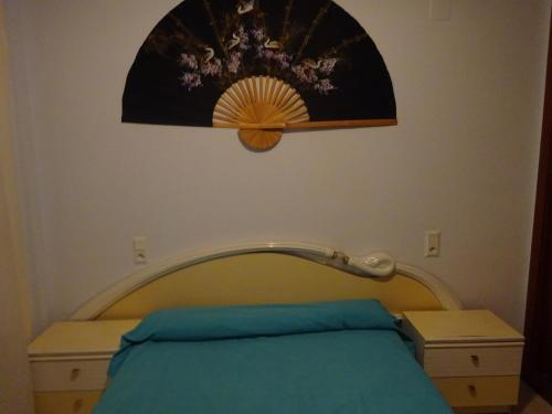 ラ・ピネーダにあるFaraon Parkのベッドルーム1室(ベッド1台付)が備わります。壁には絵画が飾られています。