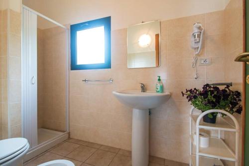a bathroom with a sink and a shower and a toilet at Agriturismo Paulesa in Cala Gonone