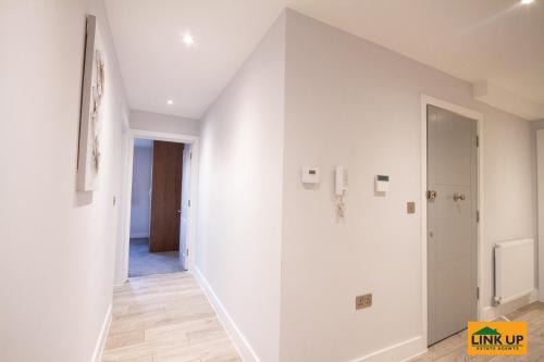 a hallway with white walls and a staircase in a house at Holden Court Apartments - Apt 6 in West Drayton