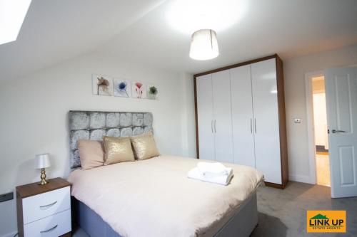 a bedroom with a large white bed and a mirror at Holden Court Apartments - Apt 6 in West Drayton