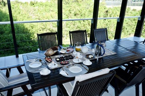ein Tisch mit Essen und Getränken auf einem Balkon in der Unterkunft Normarie's Guesthouse in Wilderness