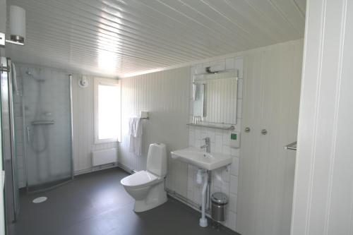a white bathroom with a toilet and a sink at Drottning Victorias Hotell & Vilohem in Borgholm