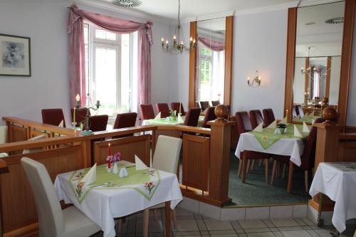 a restaurant with tables and chairs and a mirror at Hotel Weisser Schwan in Erfurt