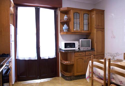 a room with a door and a microwave and a kitchen at Apartamento Mendi in Lizarraga