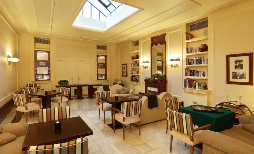 a dining room with tables and chairs and a skylight at Hotel Britania Art Deco - Lisbon Heritage Collection - Avenida in Lisbon