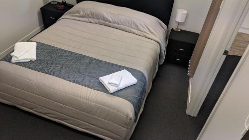 a bed with two pillows on it in a room at Cozy one bedroom apartment near Auckland Airport in Auckland