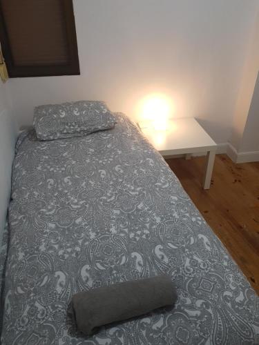 Bett in einem Zimmer mit einem Tisch neben einem Bett in der Unterkunft San Sebastián Hideaway in San Sebastián