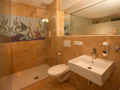 a bathroom with a toilet and a sink and a shower at Bed and Breakfast unter den Linden in Nördlingen