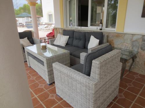 een patio met een bank, stoelen en een tafel bij Casa Gregory in Turre