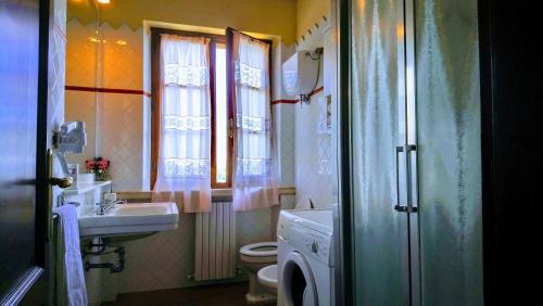 a bathroom with a sink and a toilet and window at Agriturismo Casa Rossa in Chianciano Terme