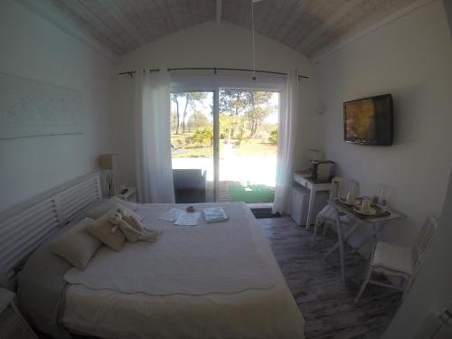 1 dormitorio con cama, escritorio y ventana en Villa Saint Barth, en Gujan-Mestras