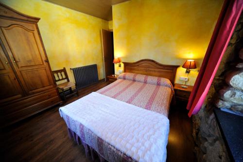 a bedroom with two beds in a room with yellow walls at Hotel Vall d´Aneu in Esterri d'Àneu