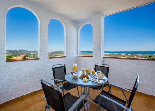 a dining room with a table and chairs and windows at Complejo Bellavista Residencial in Pego