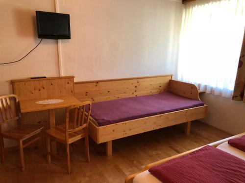 a room with a bed and a table and a tv at Pension & Ferienwohnung Dullnig in Gmünd in Kärnten