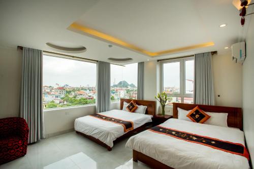 2 Betten in einem Zimmer mit einem großen Fenster in der Unterkunft Van Hoa Hotel Ninh Binh in Ninh Bình