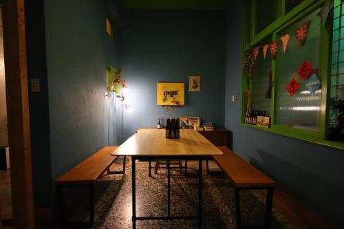 台南市にある米宿 Roomi House 台南老屋民宿の木製テーブルとベンチ2台が備わる客室です。
