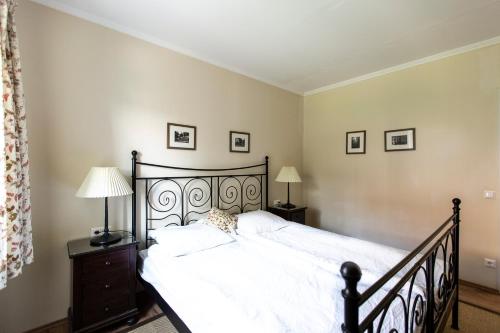 a bedroom with a bed with white sheets and two lamps at Landhaus Piber in Piber
